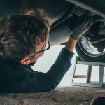 Майстер проводить діагностику ходової частини автомобіля на підйомнику