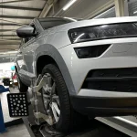 Регулювання розвалу-сходження передніх коліс автомобіля на стенді в автосервісі.